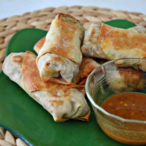 baked shrimp eggrolls on a green plate with sauce