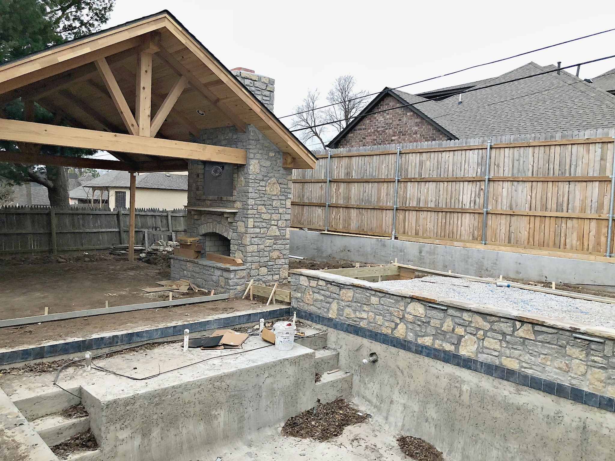 pool shell, competed fireplace and construction on cabana