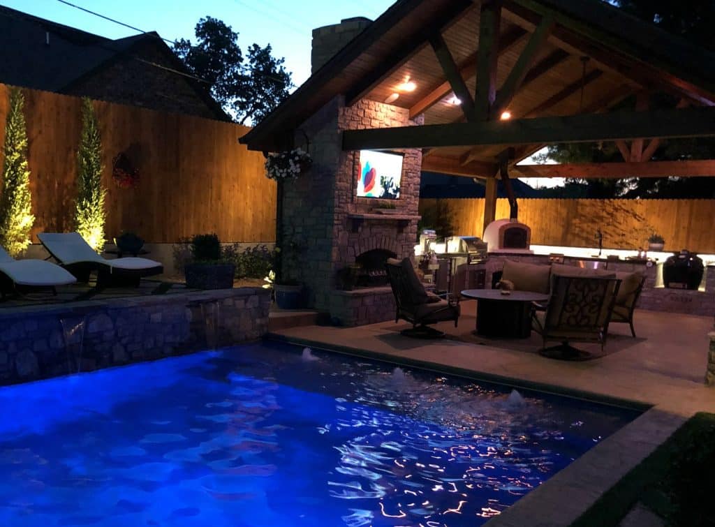 Competed outdoor living space with fireplace, tv, outdoor kitchen, pool