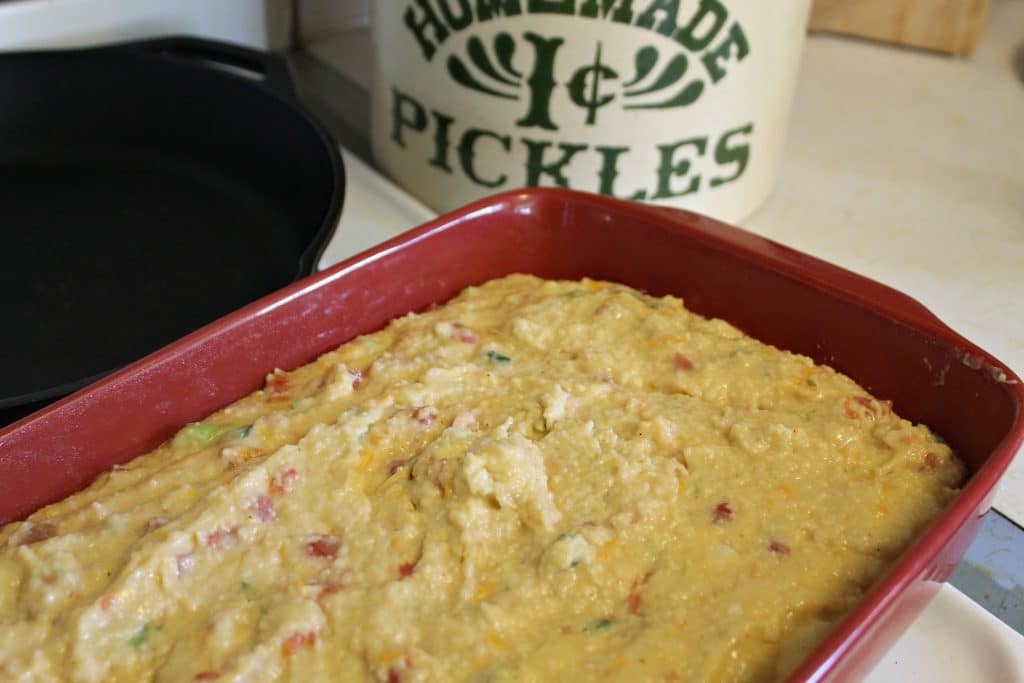 Holiday cheese grits unbaked in a red casserole dish