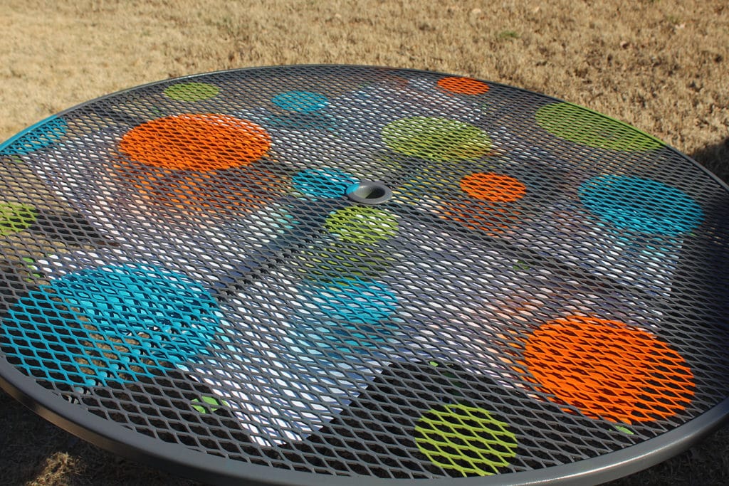 More sprayed dots all sizes on grey wrought iron patio table