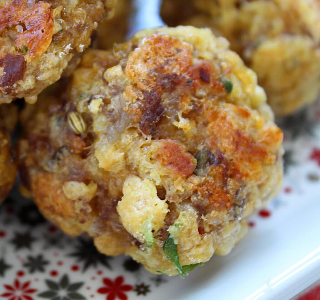 Up close sausage ball made with cornbread dressing on a holiday plate