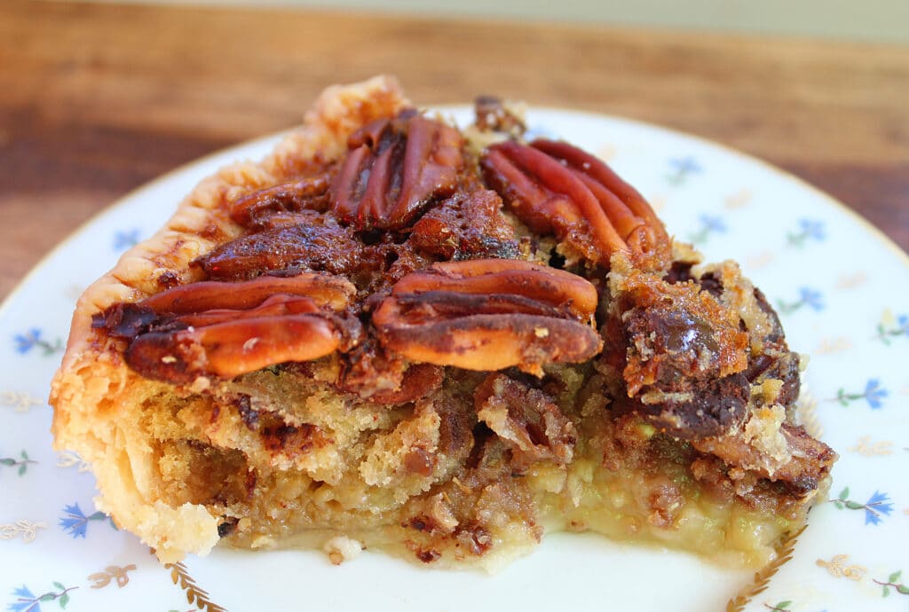 slice of chocolate orange Cointreau pecan pie on a china plate.