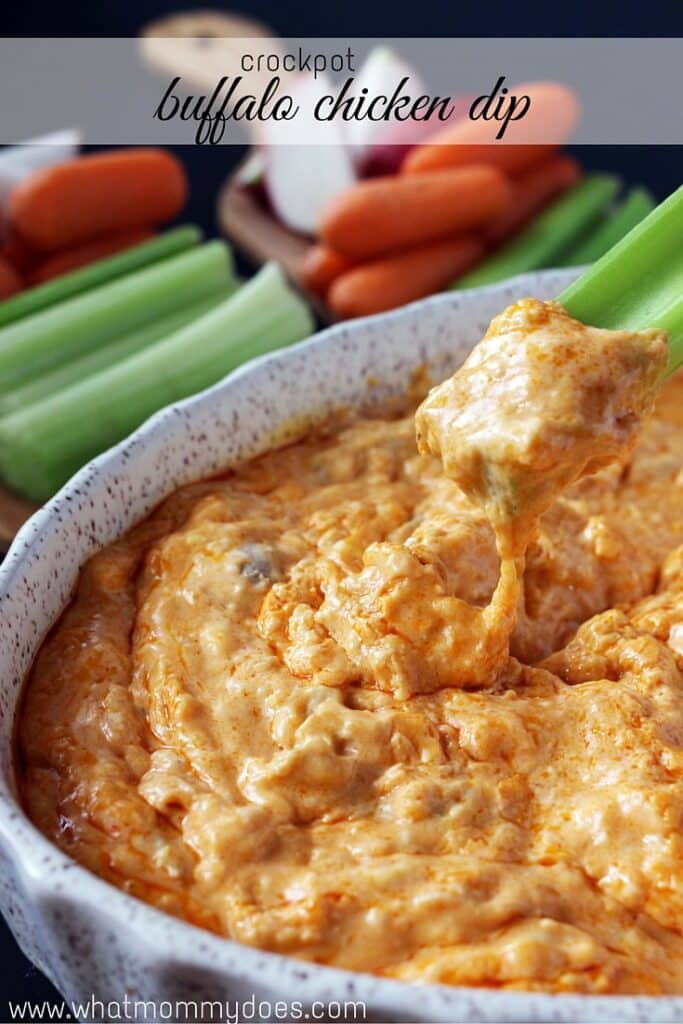 Crock pot Buffalo Chicken Dip in a white bowl with celery and carrots