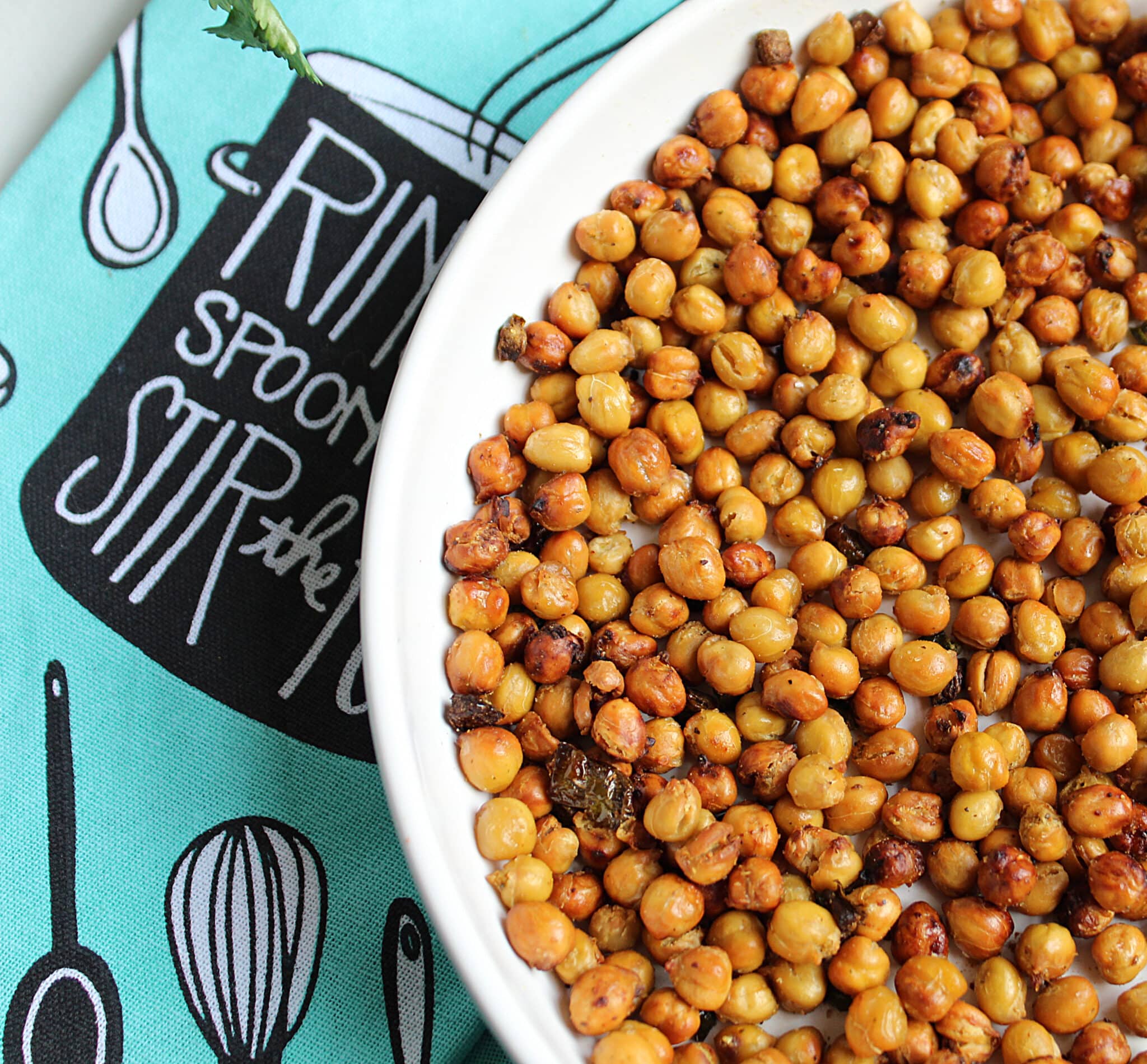 crunchy roasted chickpeas with jalapenos in a white bowl on a turquoise blue dish towel