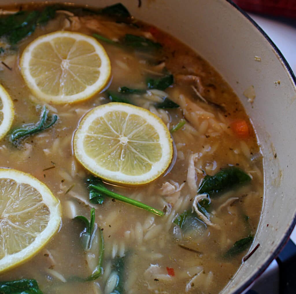 lemon chicken orzo soup with lemon slices in a dutch oven