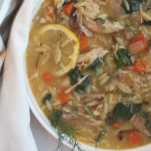 lemon chicken orzo soup in a white serving bowl