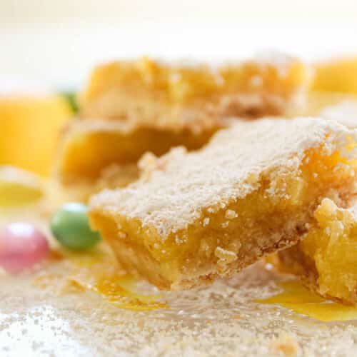 Lemon Bars with Almond Shortbread Crust on a crystal serving plate.