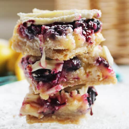 close up of stacked white chocolate blueberry lemon bars