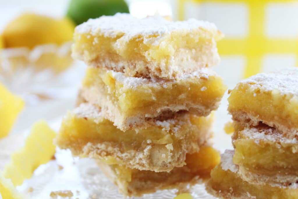 2 stacks or stacked lemon bars on a crystal plate.