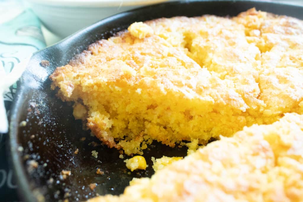 upclose picture of cut cornbread in a cast iron skillet