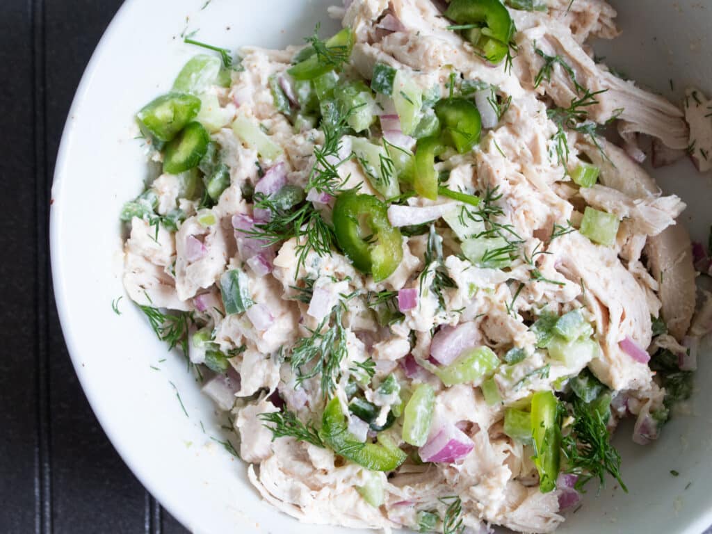 close up of chicken salad with jalapenos, red onion and fresh dill