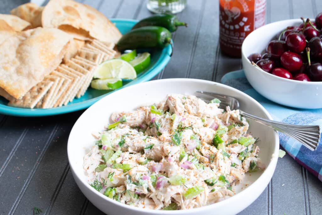 healthy chicken salad with crackers, extra lime, jalapenos, low carb tortillas and fresh cherries on the side with hot sauce