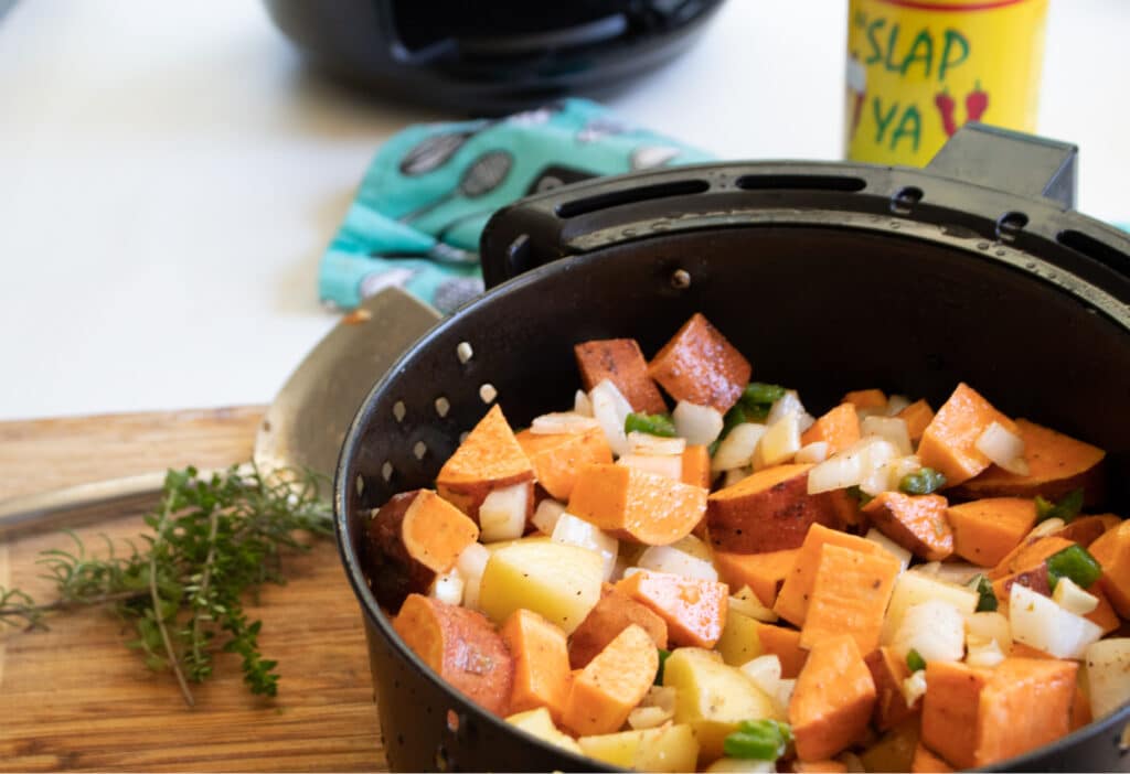 Raw sweet potato hash in the air fryer basket.