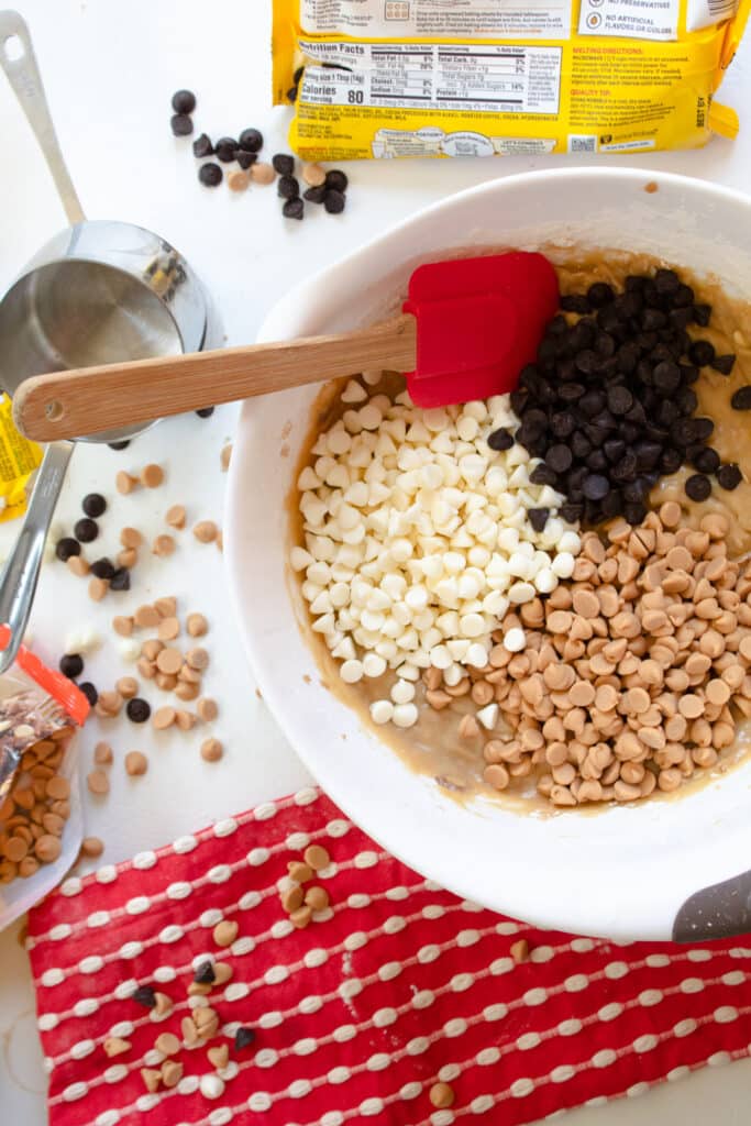 mixing bowl with brownie mixture and 3 kinds of chocolate chips on top