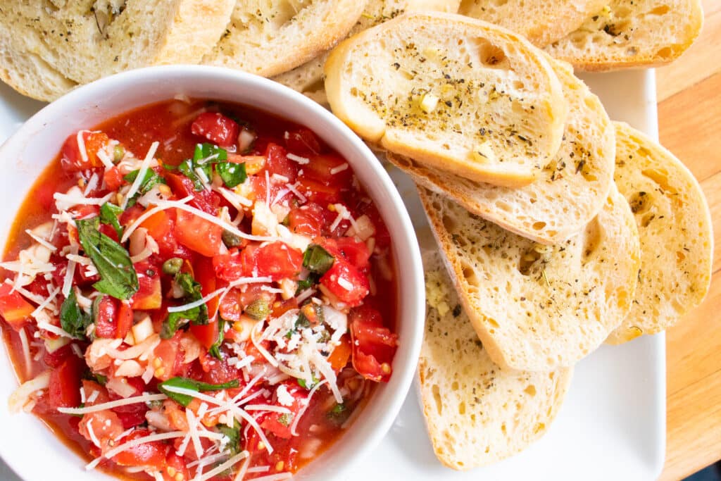 overhead shot of garden fresh tomato basil bruschetta and crusty garlic bread crudites