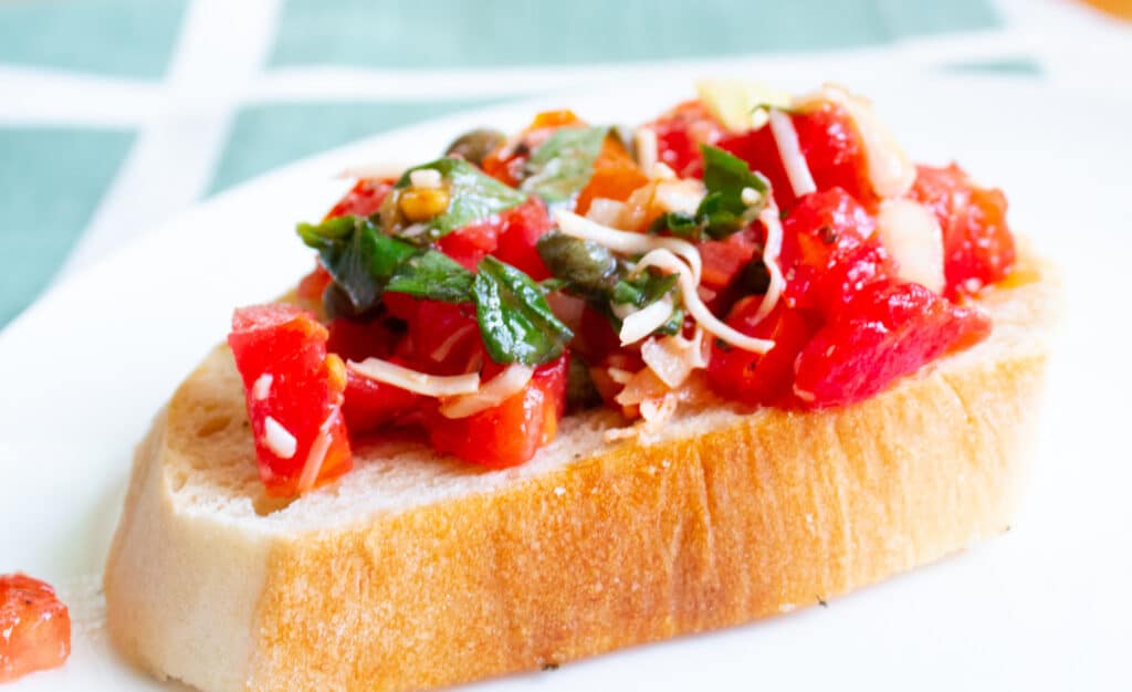 side view of garden fresh tomato basil bruschetta on a crusty crudite