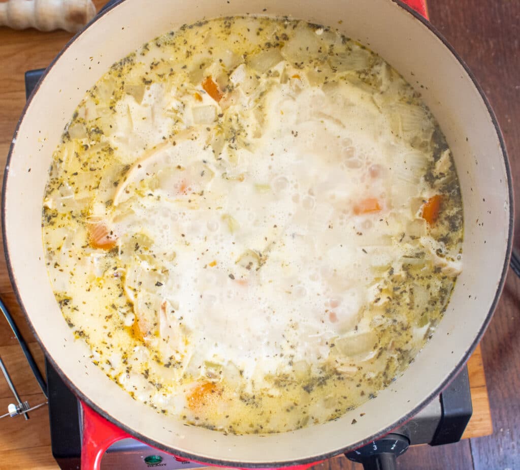 overhead picture of boiling herb broth with veggies