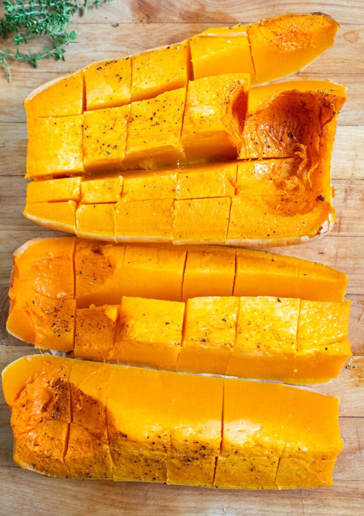 quartered roasted butternut squash on a cutting board