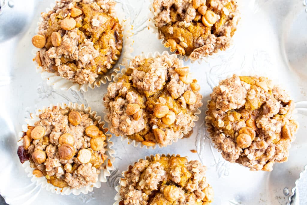 close up overhead of pumpkin muffins with oat butterscotch pumpkin pie spice topping. on a silver retro tray