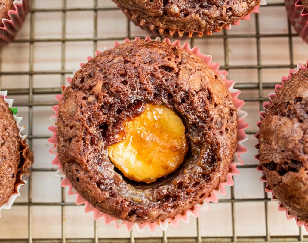 Overhead unfrosted picture of a brownie cupcakewith a banana in the center out of the oven.