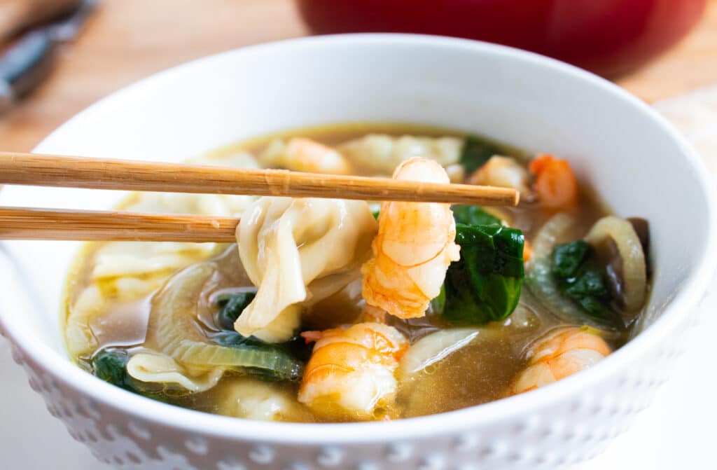 easy 30 minute shrimp wonton soup in a white bowl with chop sticks