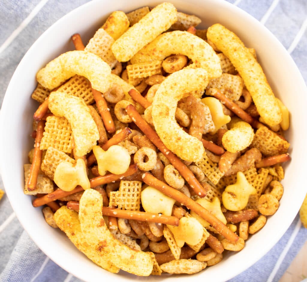 overhead picture of curry cheese puff chex mix in a white bowl