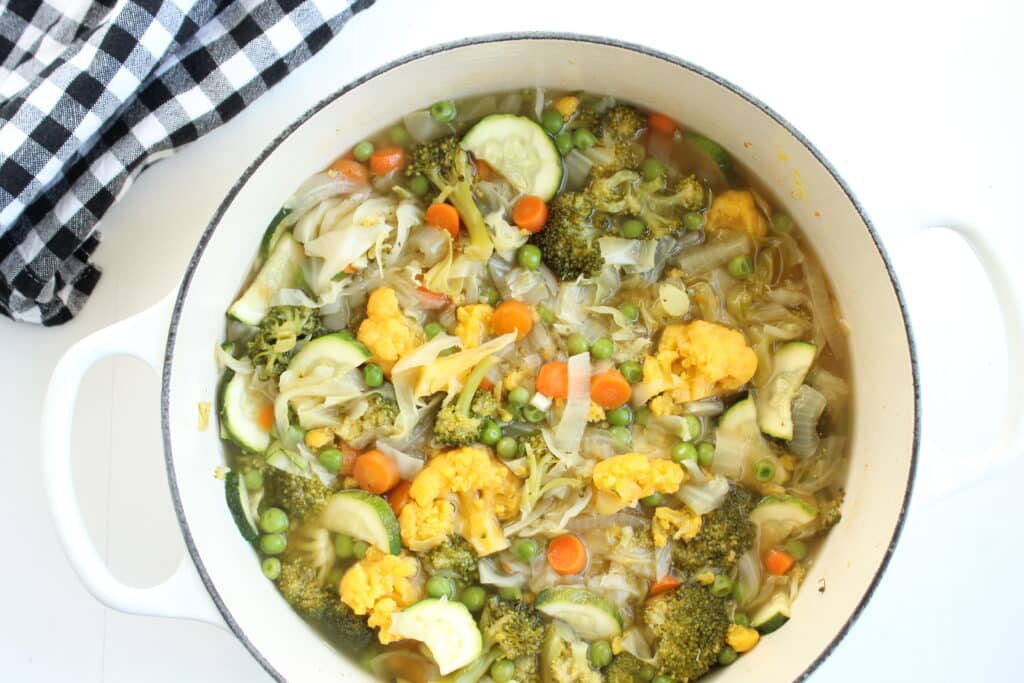 easy vegetable cabbage soup in a white dutch oven after it's cooked.