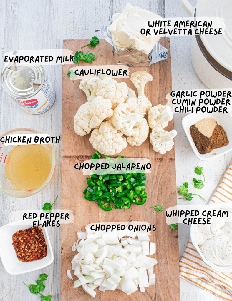 White Cauliflower Queso Recipe Ingredients with labels and on a wooded square cutting board.