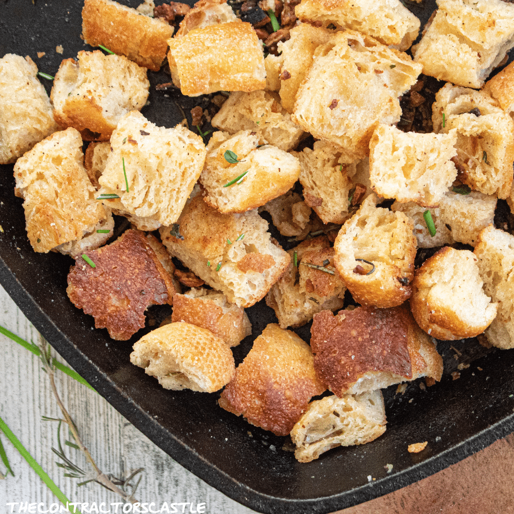 golden and crusty simple homemade croutons in a cast iron skillet.