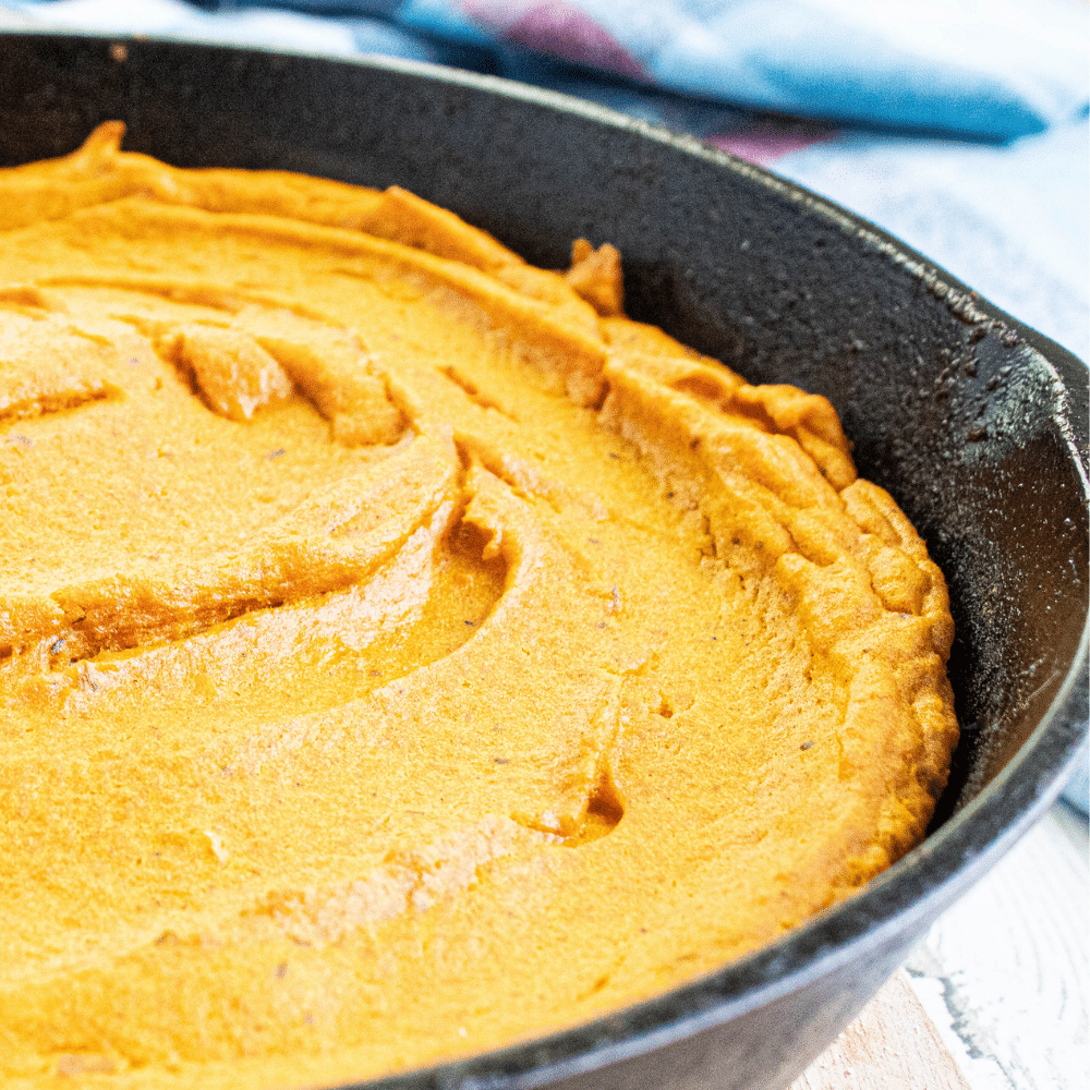 Side picture of brown butter carrot souffle in a cast iron skillet.