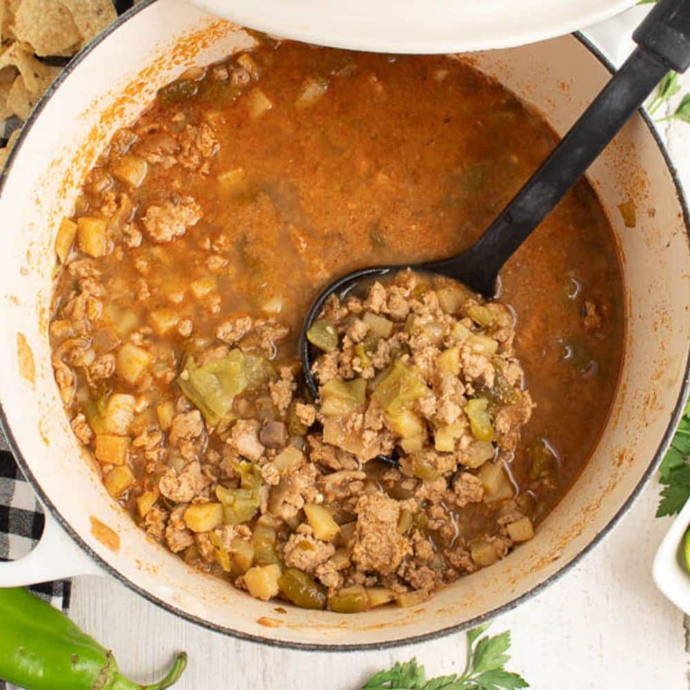 ground turkey green chili soup in a white dutch oven