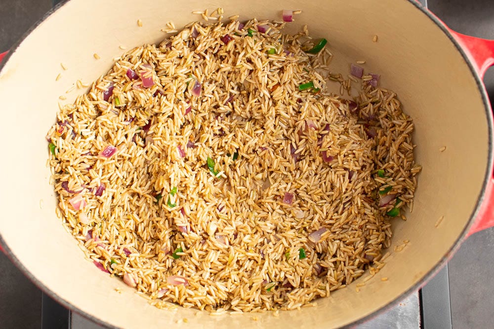 Brown rice sauting in butter, onion, jalapeno, garlic mixture in a dutch oven.