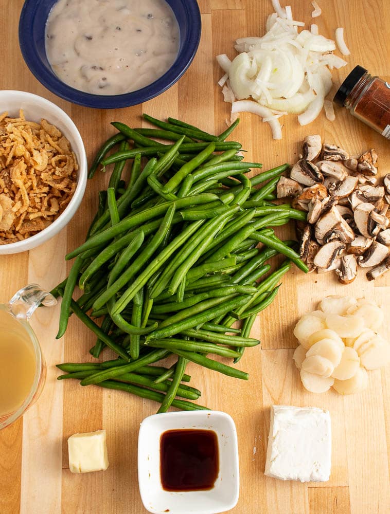 Green bean casserole with water chestnuts ingredients on a butcher block cutting board.