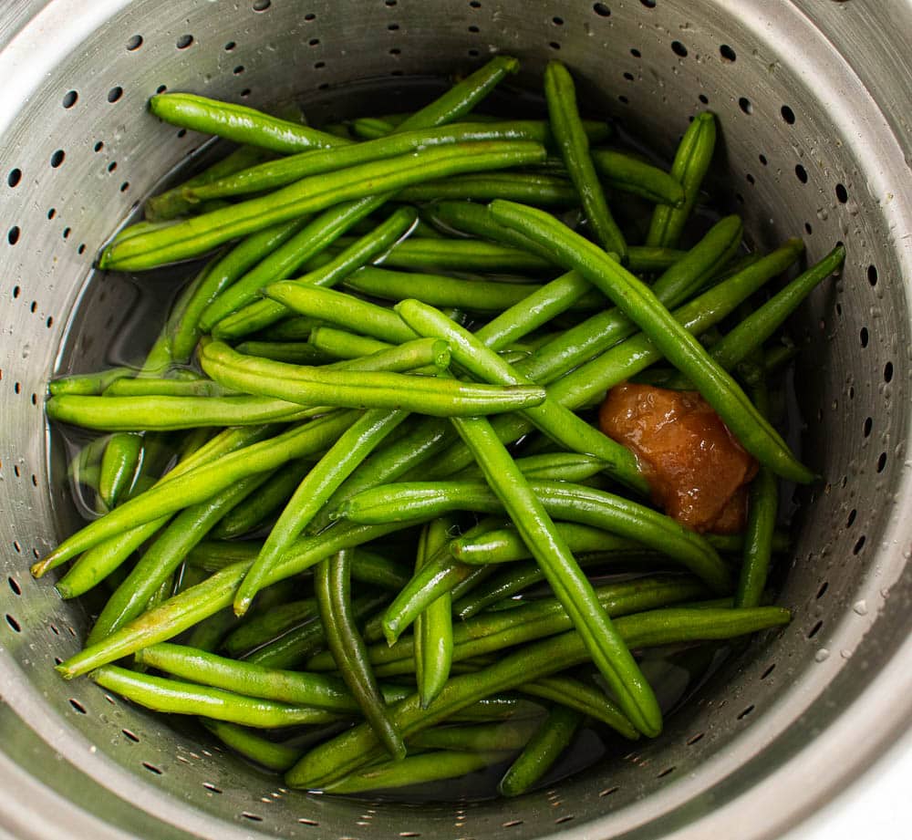 Fresh Green Beans in a large metal pot with boullion paste and water.