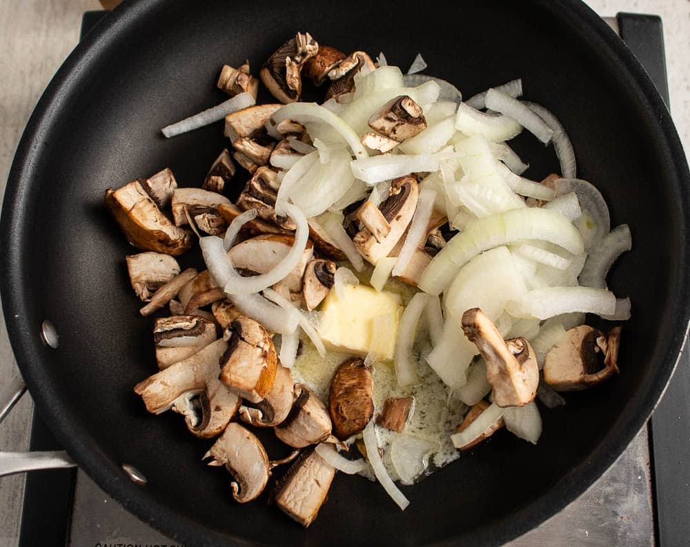 mushrooms, onions, garlic in a non stick skillet sauteing in butter.