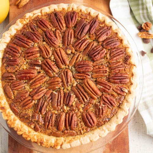 Whole Chocolate Orange Pecan Pie on a wooden serving board.