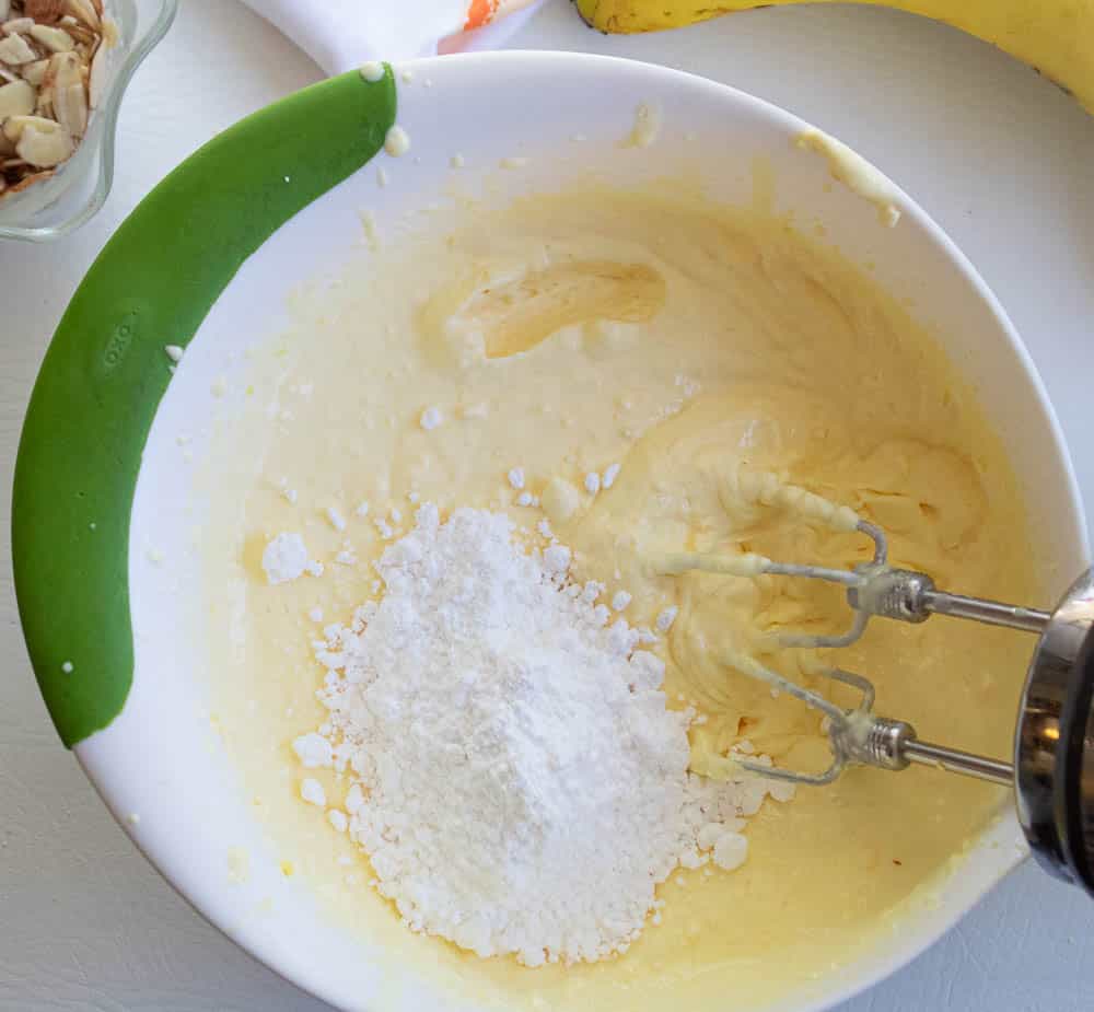 Milk and French vanilla pudding mix in a white bowl with hand mixer beaters.