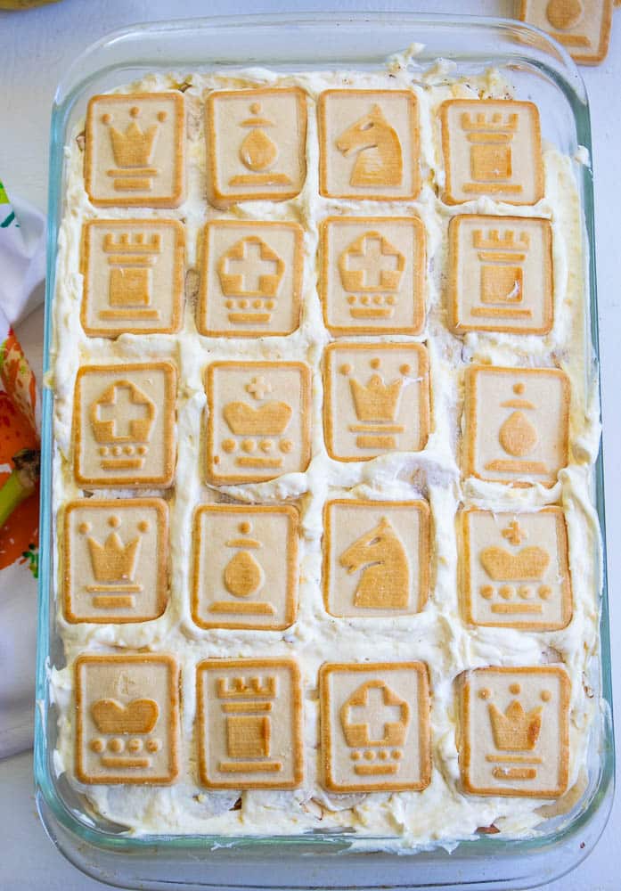 Final layer of chessmen cookies on top of Best No Bake Banana Pudding Recipe with Cream Cheese.