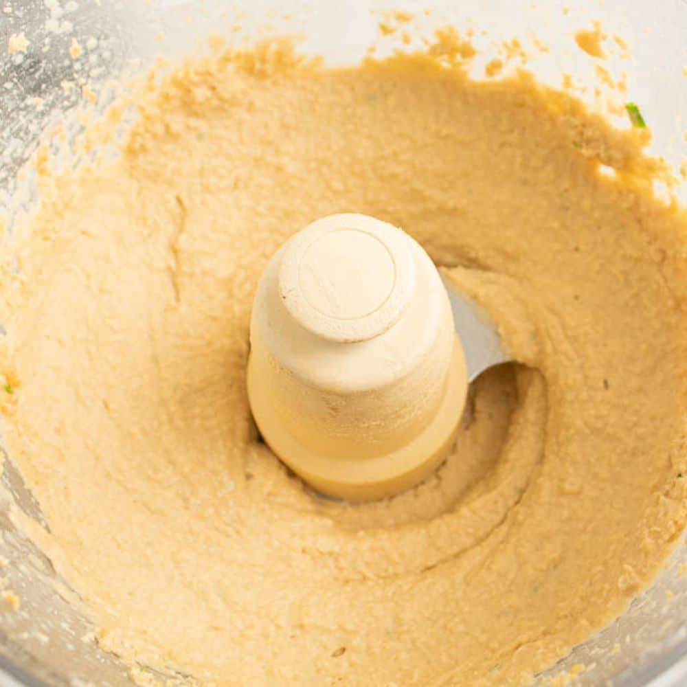 Smooth and creamy hummus dip in a food processor.