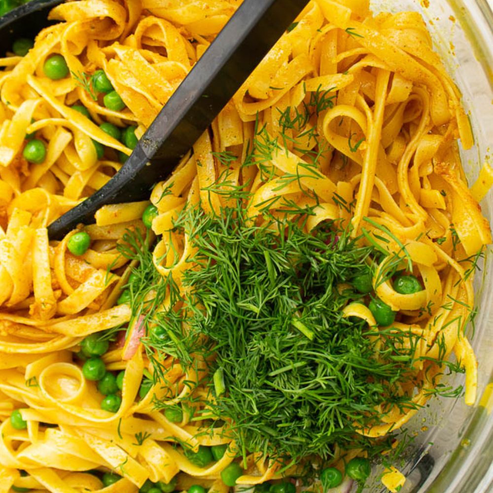 Curry butter tossed in fettuccini pasta with red onions, peas, and fresh dill.