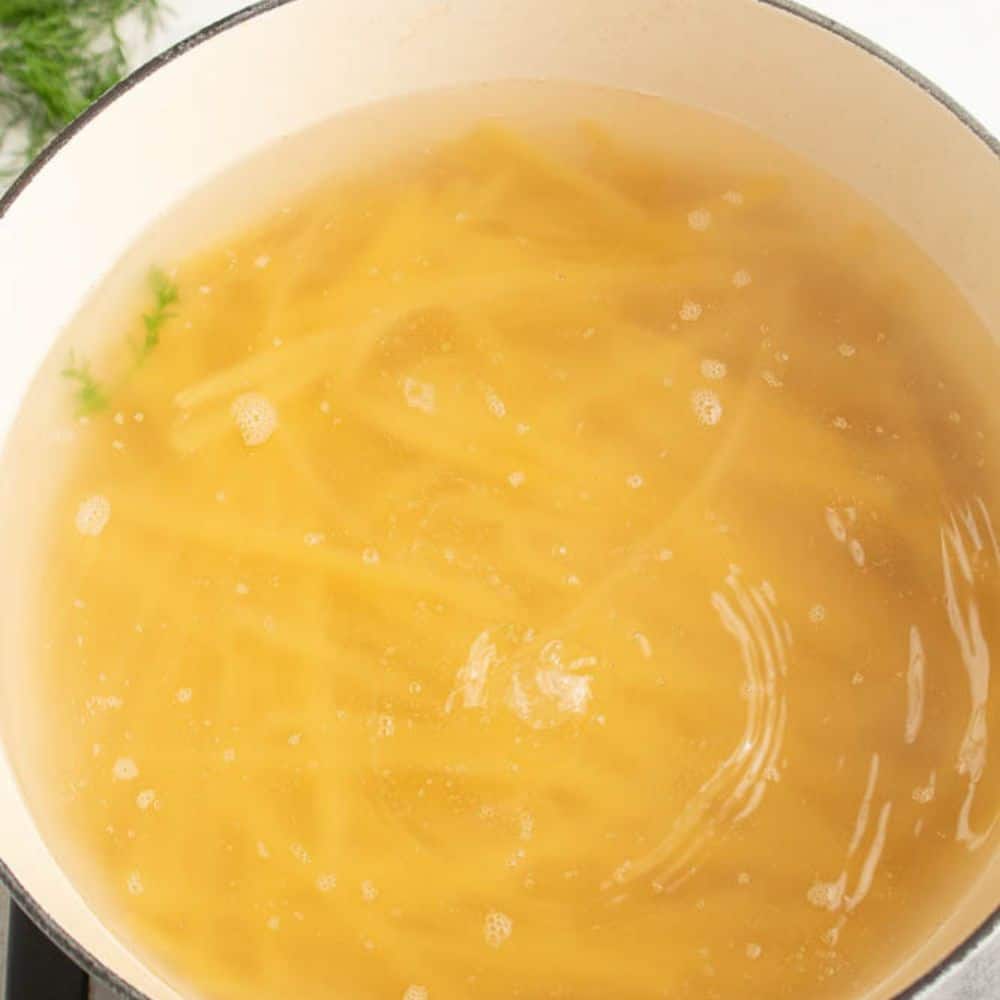 Dutch oven with boiling water and pasta.