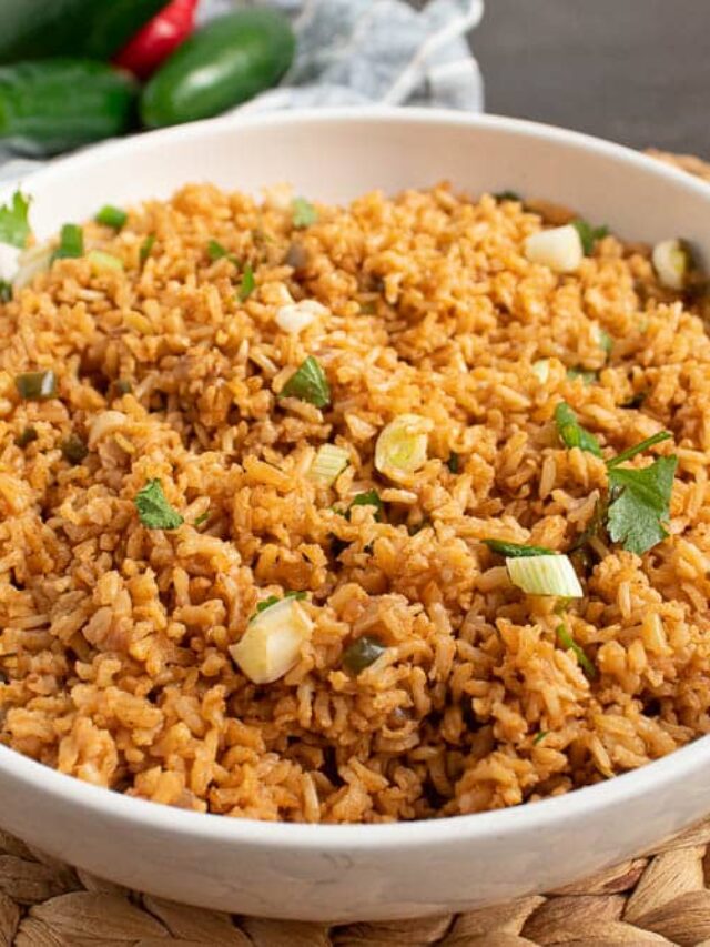 45 angle full bowl mex rice background with jalapenos on a bamboo placemat.