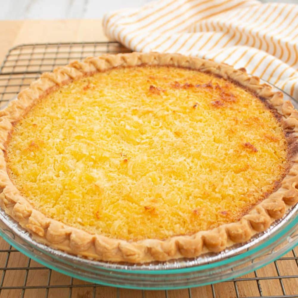 Creamy pineapple coconut pie on a wire baking rack.